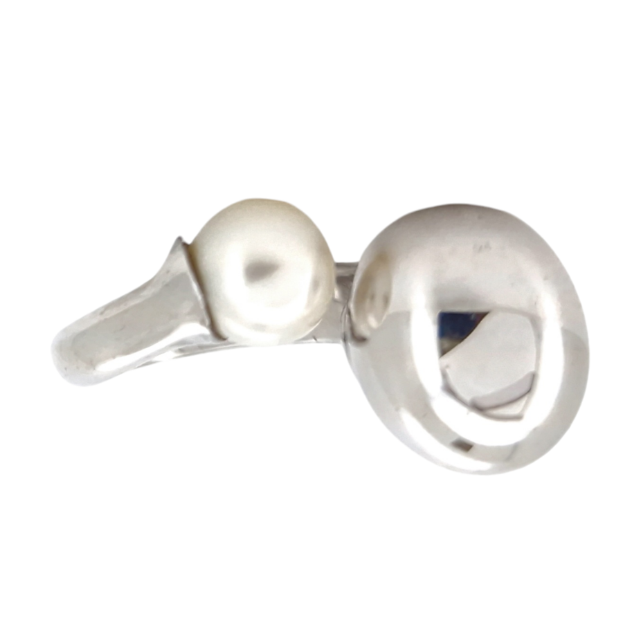 Este sofisticado anillo de acero inoxidable, firmado por la marca BREL, combina la durabilidad y modernidad del acero con la elegancia de una perla cultivada de 12 mm. El diseño contemporáneo de este anillo, junto con la textura brillante del acero y la suavidad de la perla, lo convierte en una pieza llamativa que destaca por su simplicidad y estilo. Con un peso total de 15,70 gramos y una talla nº 12, esta joya está lista para ser llevada en cualquier ocasión. El anillo ha sido restaurado por nuestros expertos joyeros, sometido a un tratamiento de fuego, ácido y pulido final, lo que garantiza que esté en perfectas condiciones para ser reestrenado. Cualidades del Acero en Joyería El acero inoxidable es ampliamente utilizado en la joyería moderna debido a su resistencia y durabilidad. No se oxida ni se corroe fácilmente, lo que lo hace ideal para piezas de uso frecuente. Además, su capacidad para mantener el brillo y resistir rayaduras lo convierte en un material de bajo mantenimiento. El acero también es hipoalergénico, lo que lo hace adecuado para personas con piel sensible o alergias a otros metales, como el níquel. Simbolismo del Acero y la Perla El acero simboliza fuerza, resistencia y durabilidad, siendo un material que representa la protección y la permanencia. Por otro lado, la perla cultivada es símbolo de pureza, sabiduría y feminidad. En este anillo, la combinación del acero y la perla crea un equilibrio entre la fuerza y la suavidad, representando tanto la fortaleza interior como la belleza y delicadeza externa. Características del Producto: Material: Acero inoxidable Perla: Perla cultivada de 12 mm de diámetro Peso total: 15,70 gramos Dimensiones: 2 cm de diámetro Tamaño del anillo: 12 Estado: Joya restaurada y garantizada por nuestros expertos joyeros Facilidades de pago: Este anillo puede ser tuyo con plazos mensuales sin intereses. Además, aceptamos oro usado como parte del pago, facilitando la compra de esta pieza única. Haz de este anillo de acero con perla cultivada una joya esencial en tu colección, una pieza que combina fuerza, estilo y elegancia.